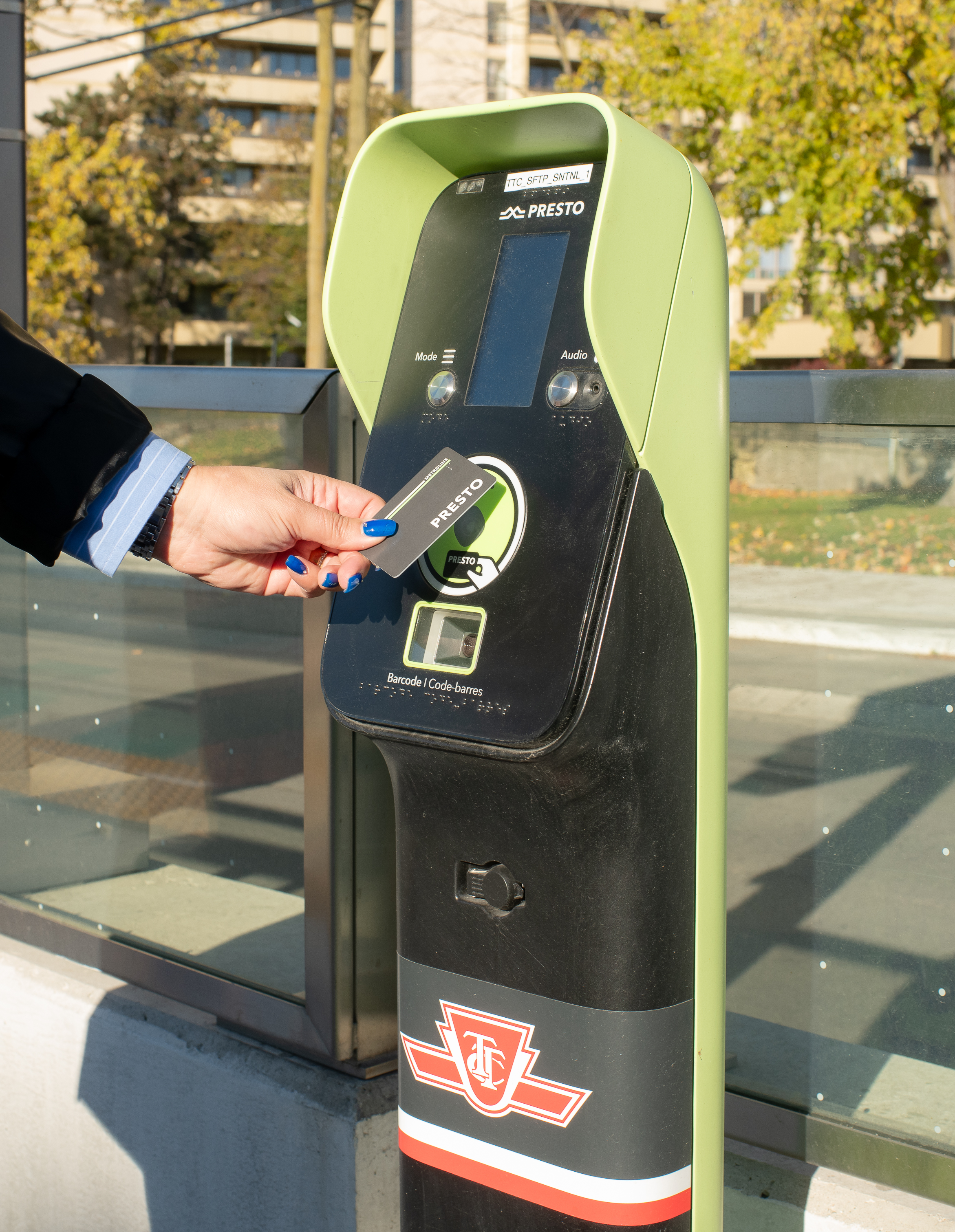 A person’s handing tapping a PRESTO card on a Standard Fare Transaction Processer