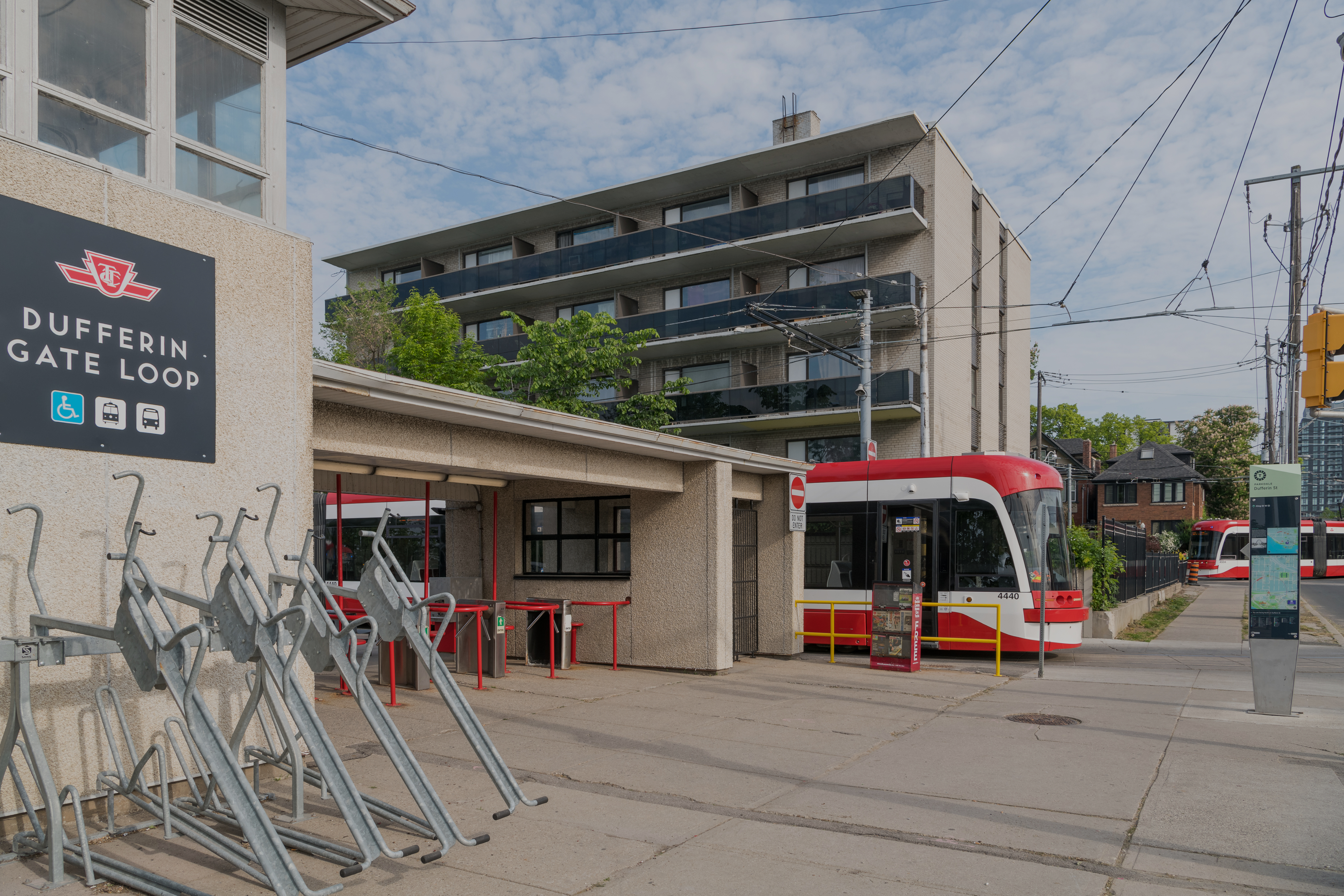 A Dufferin Gate Loop sign in the foreground with a TTC streetcar in the background.