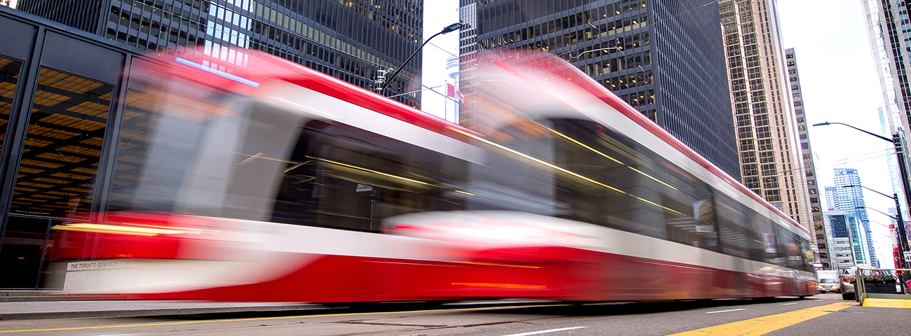Two streetcars travelling quickly, even the the camera lens cannot quite capture their speed.