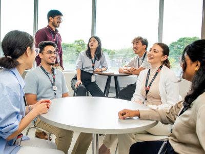 Seven students talking together at a table