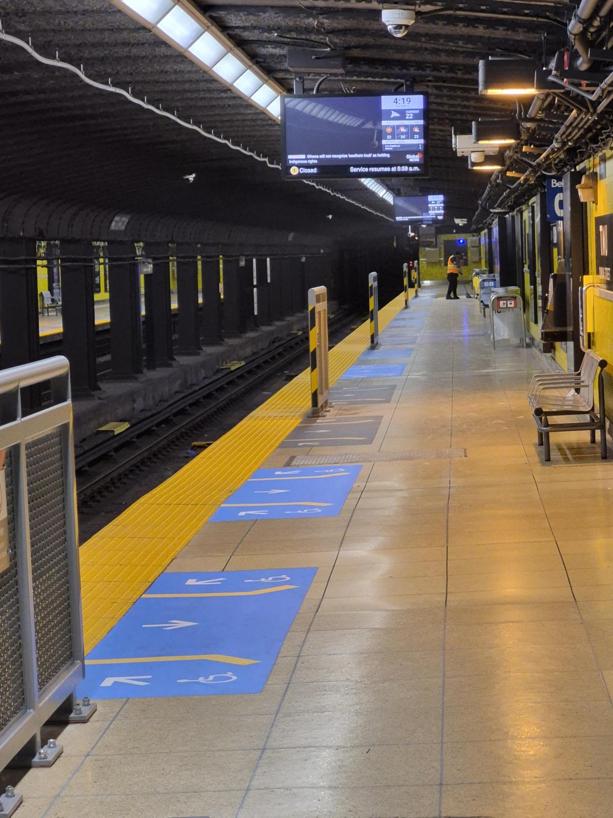 Metal platform edge barriers on the TMU Station subway platform installed beside the yellow line.