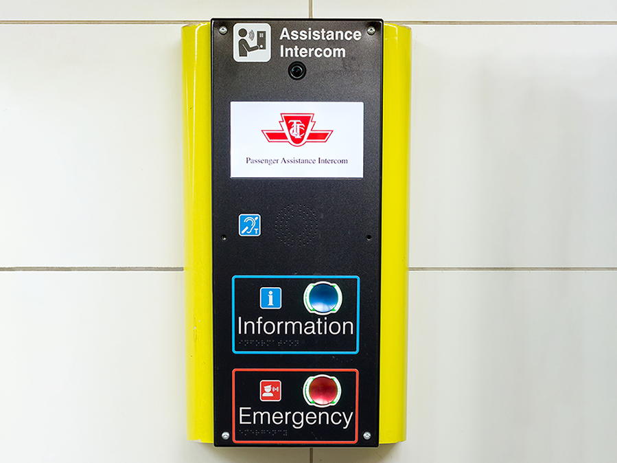 A yellow and black Passenger Assistance Intercom with blue and red buttons for Information and Emergency.
