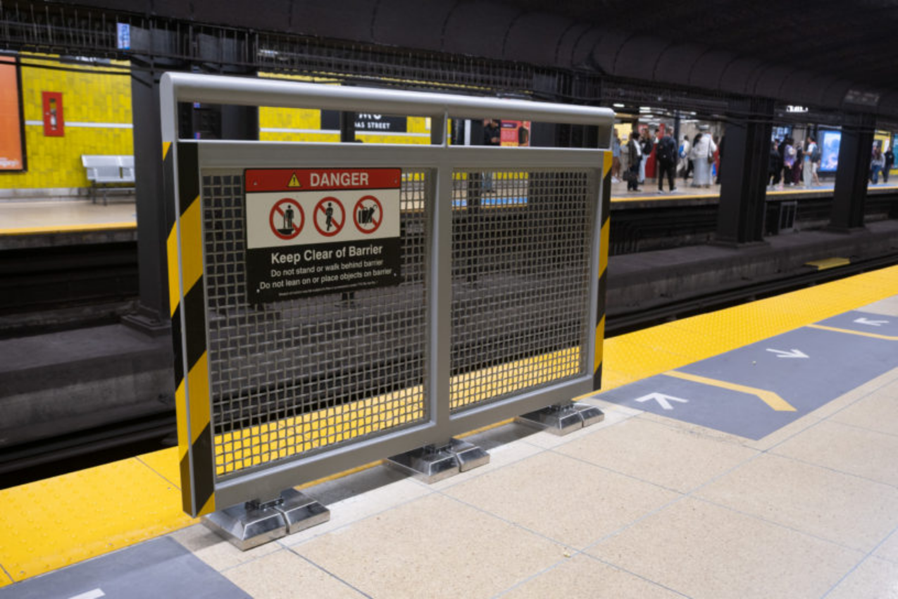 A metal barrier on the edge of a subway platform at TMU Station.