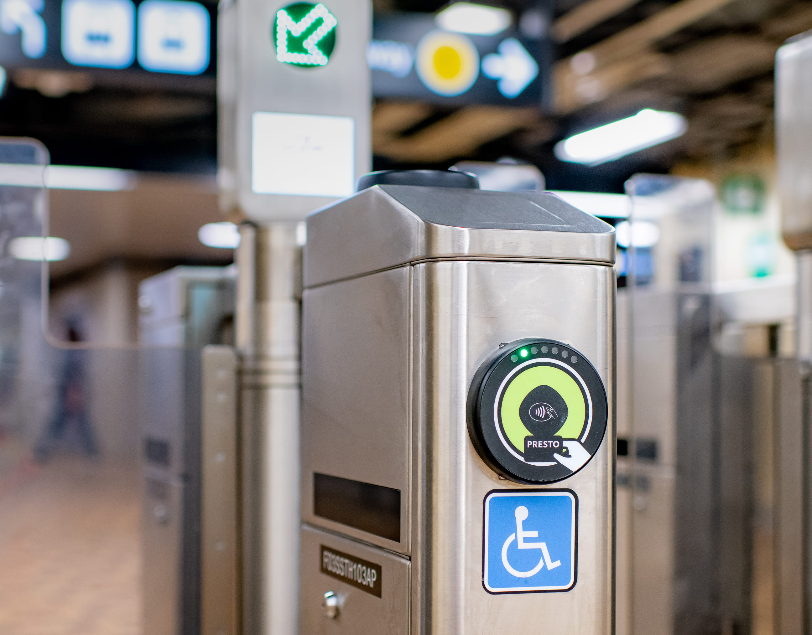 A subway station fare gate showing a green and black PRESTO reader.
