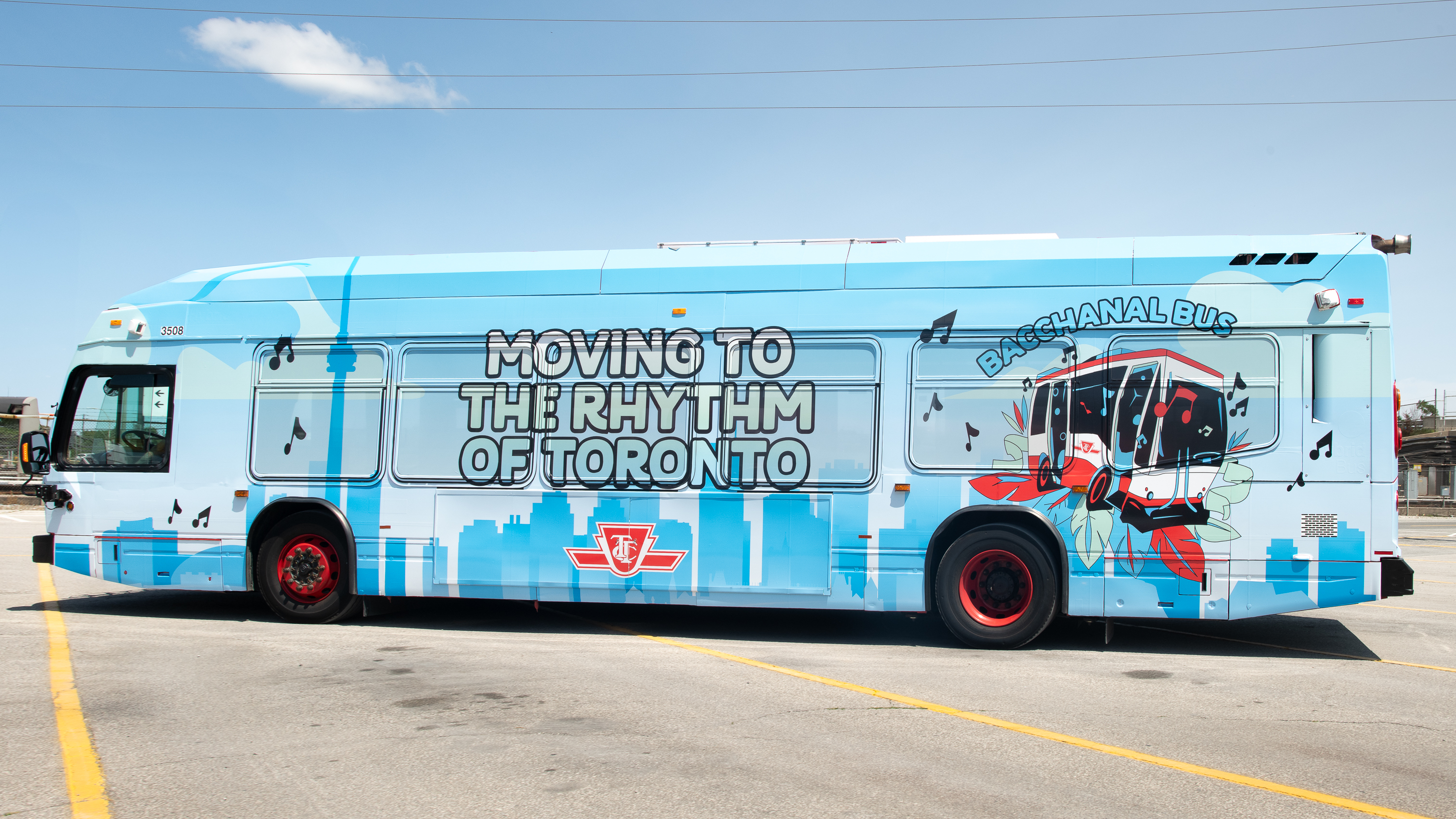 The 2026 TTC Bacchanal Bus with a blue wrap featuring the Toronto skyline, a graphic of a red and white TTC bus with music notes, and the text "Moving to the Rhythm of Toronto" and "Bacchanal Bus"