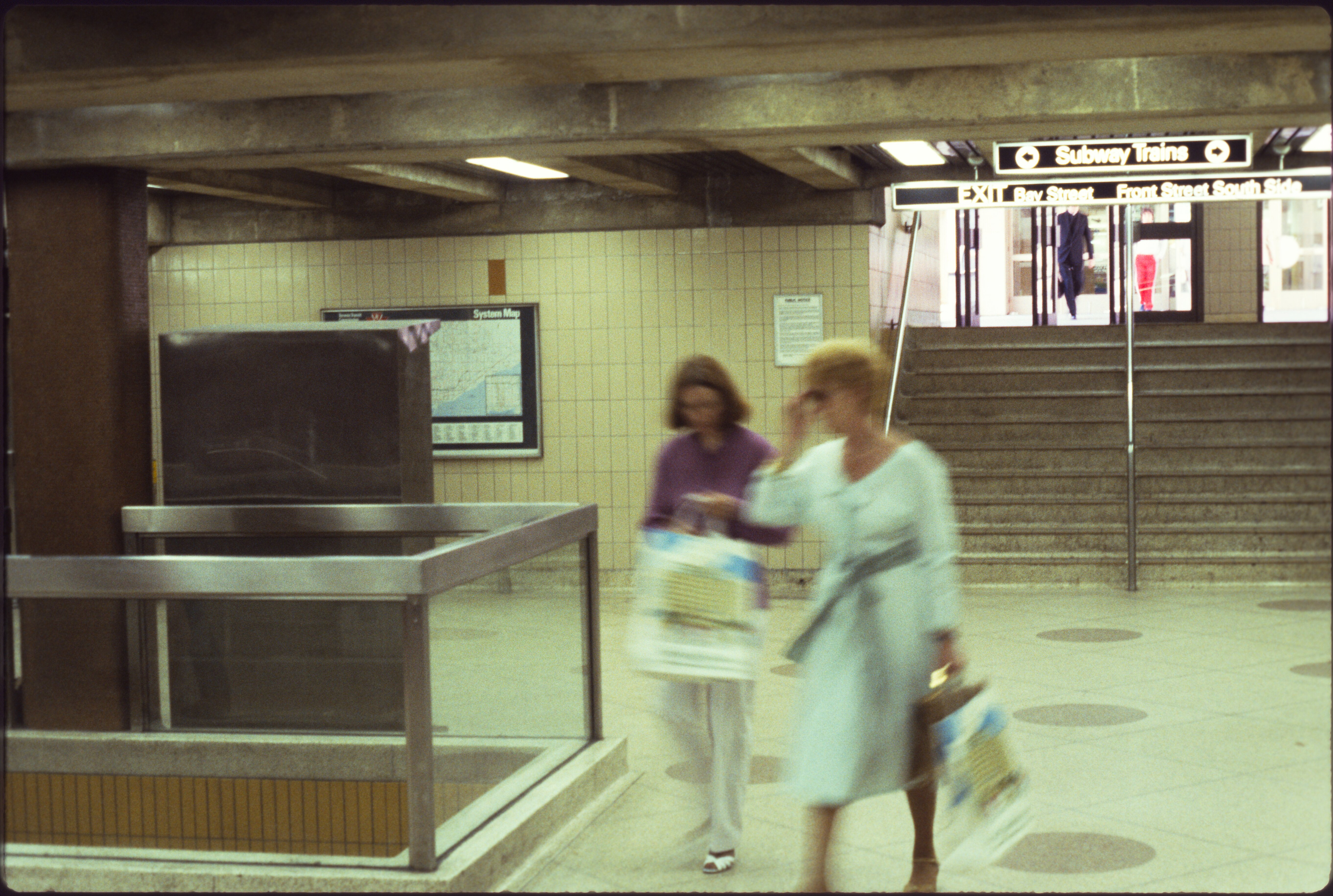 Vintage photo inside TTC’s Union Station concourse, with two women walking from a staircase/street entrance to their subway platform.