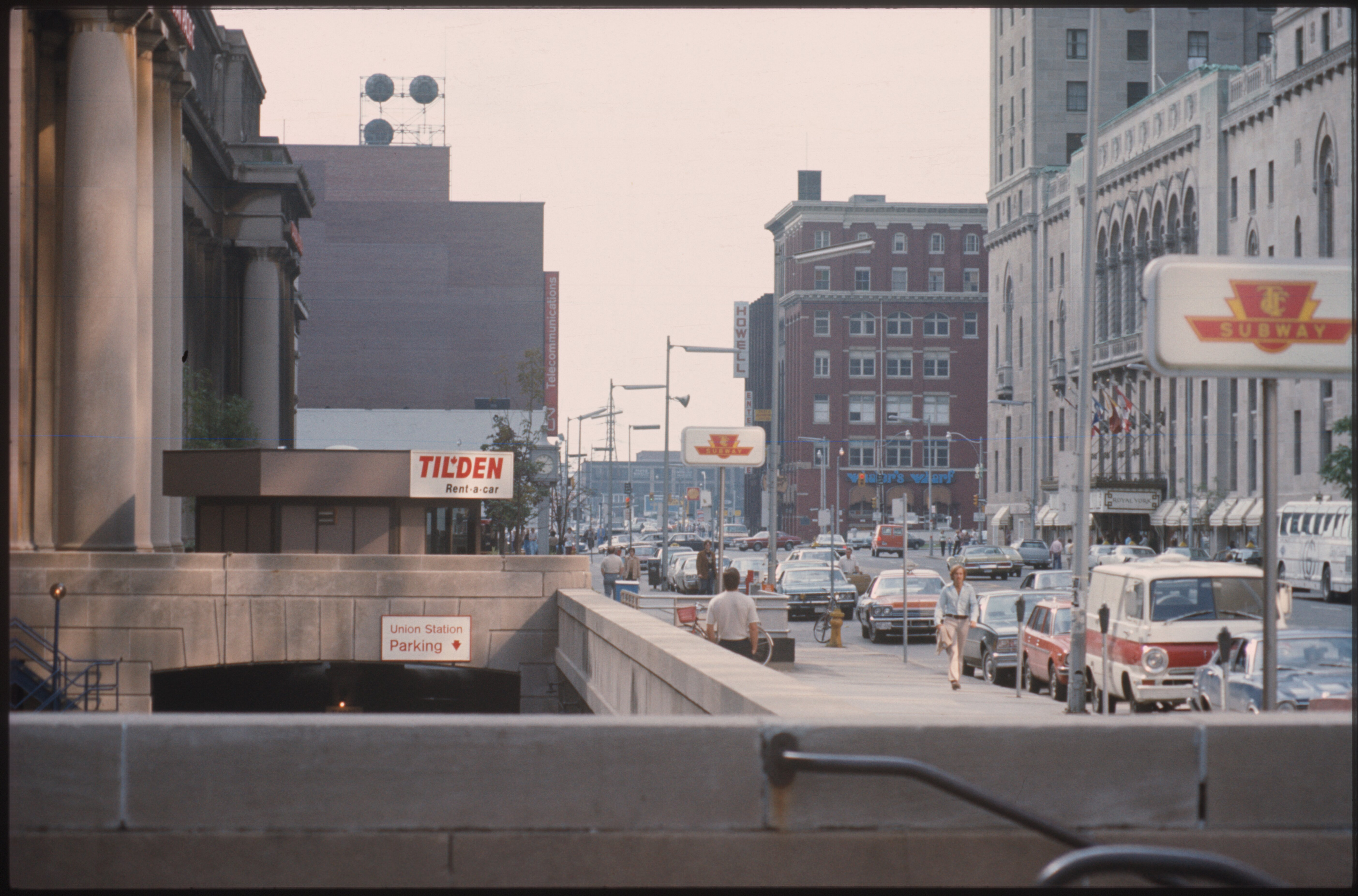 Vintage street-level photo of Union Station on Front Street, with a TTC subway sign, parked vehicles, and pedestrians.