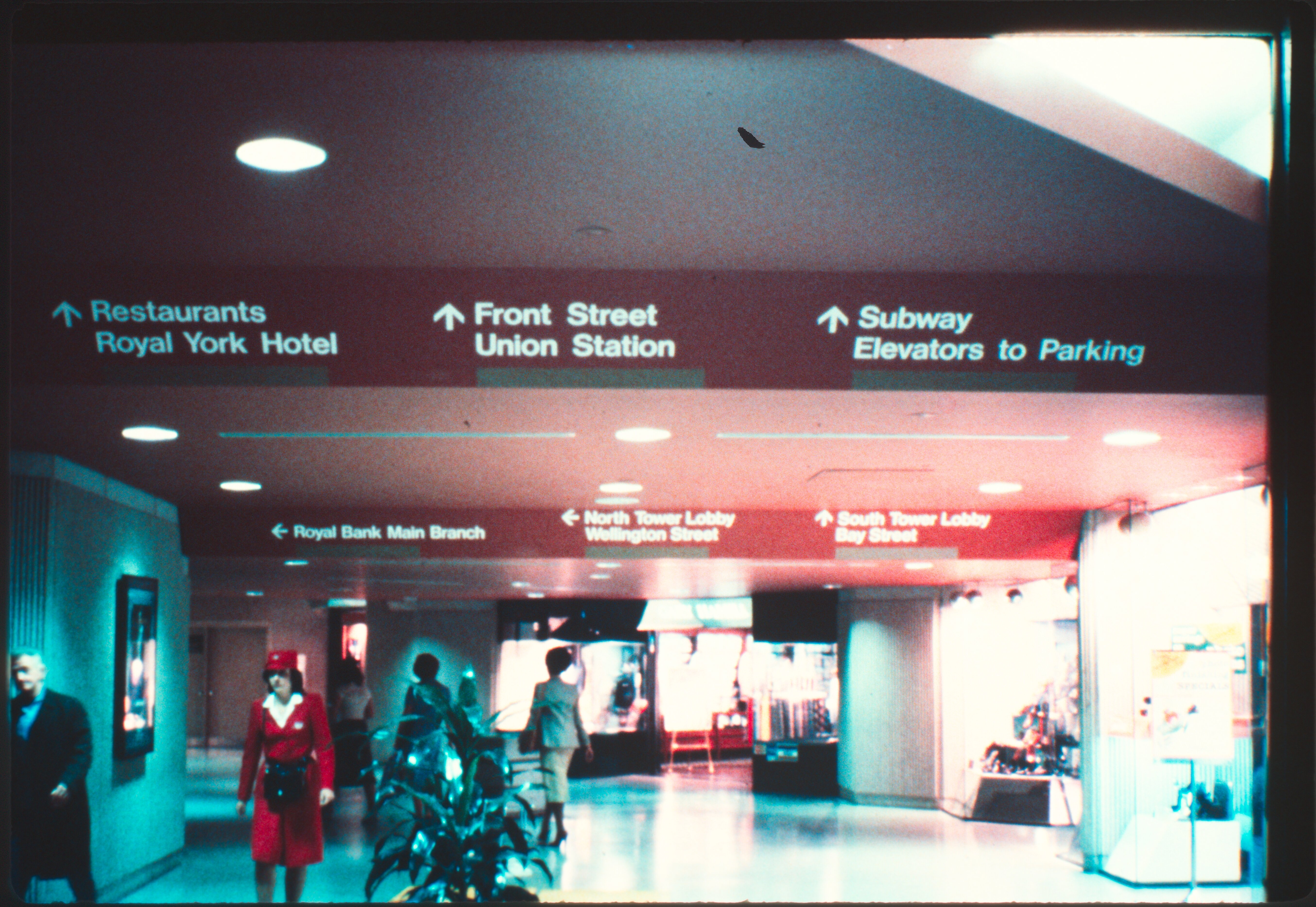 Vintage photo of a PATH lobby corridor with a TTC employee and directional signs to Union Station and nearby landmarks.