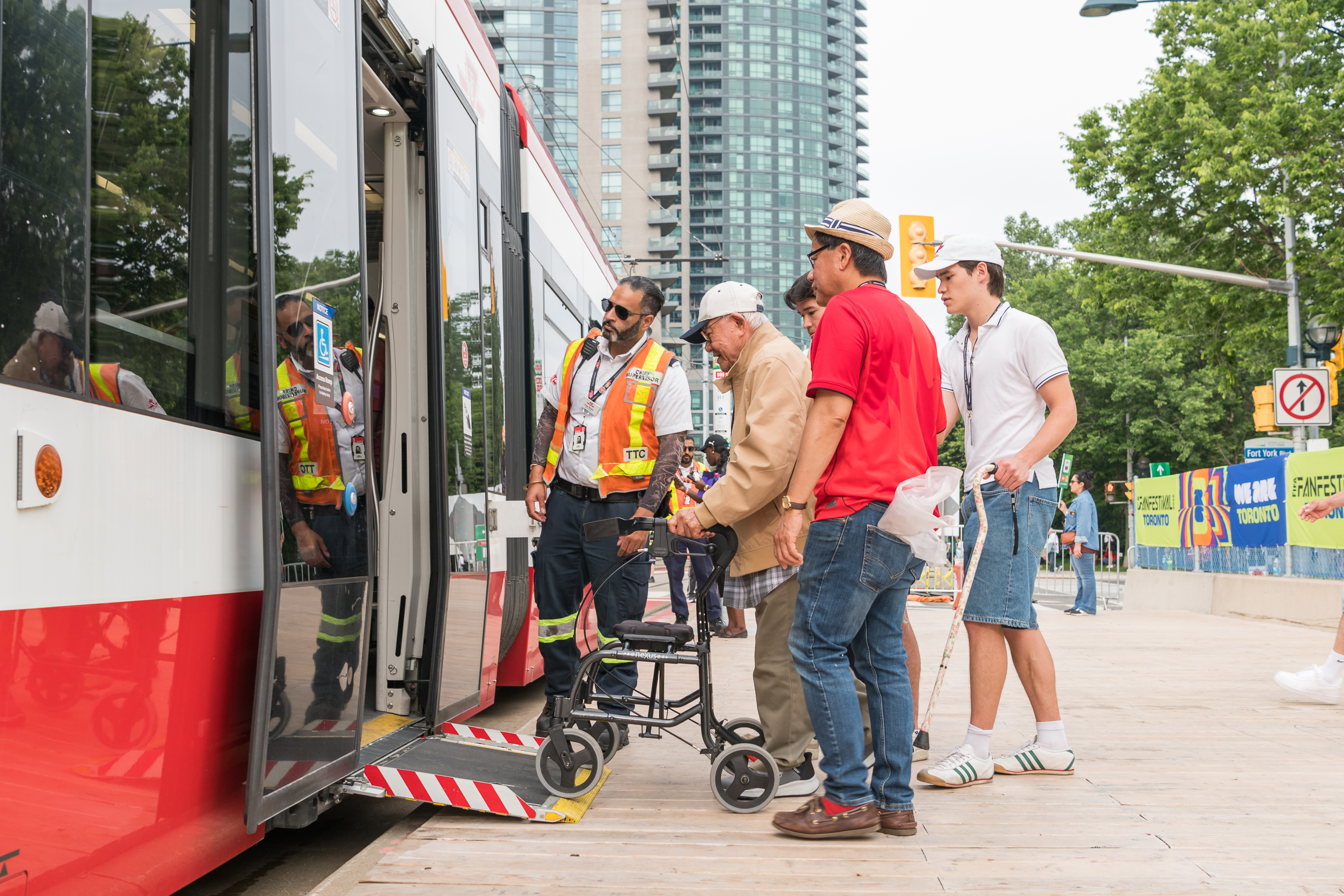 TTC Operator assissting a customer using a walker board a streetcar.