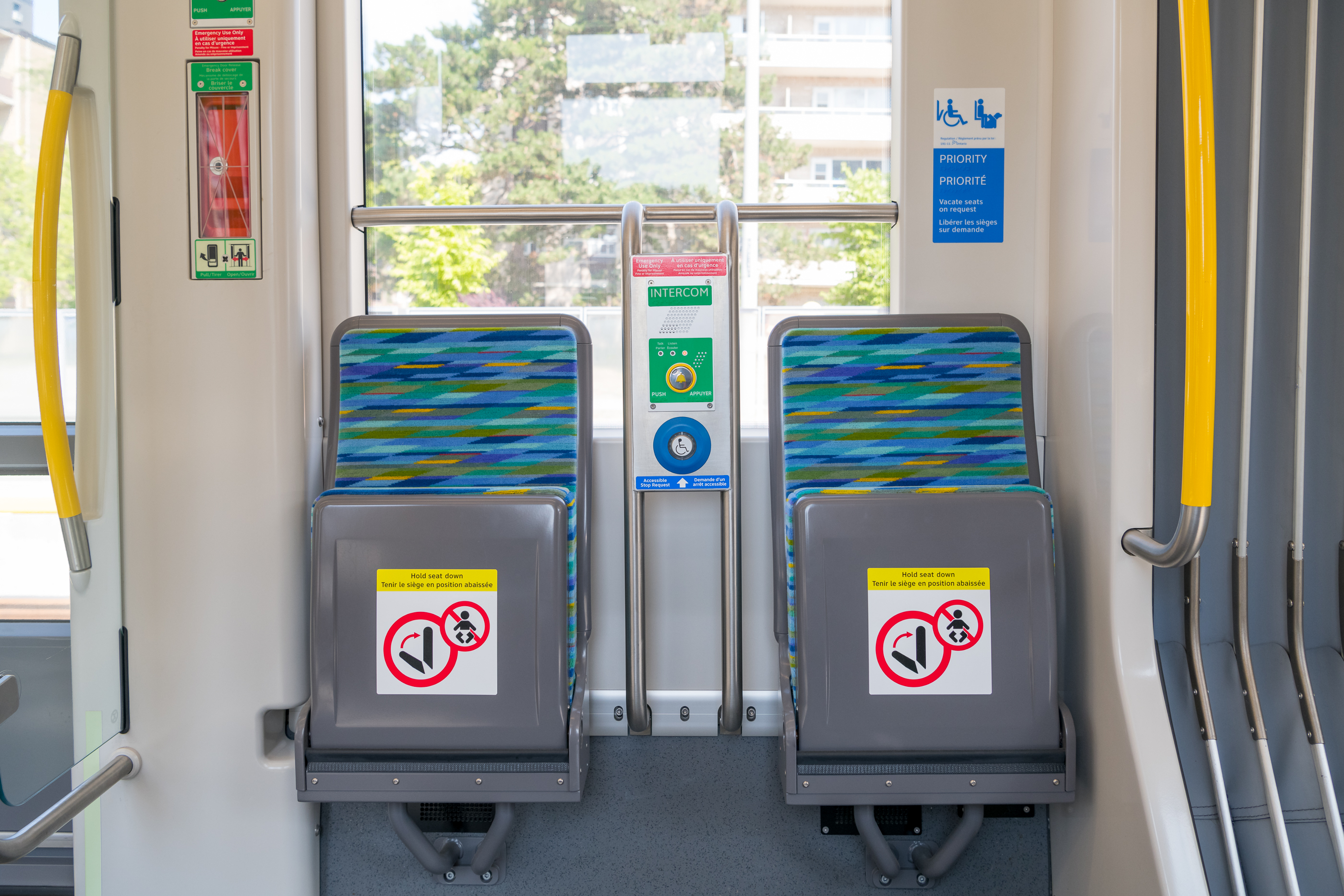 Two blue patterned priority seats on a TTC light rail transit vehicle.