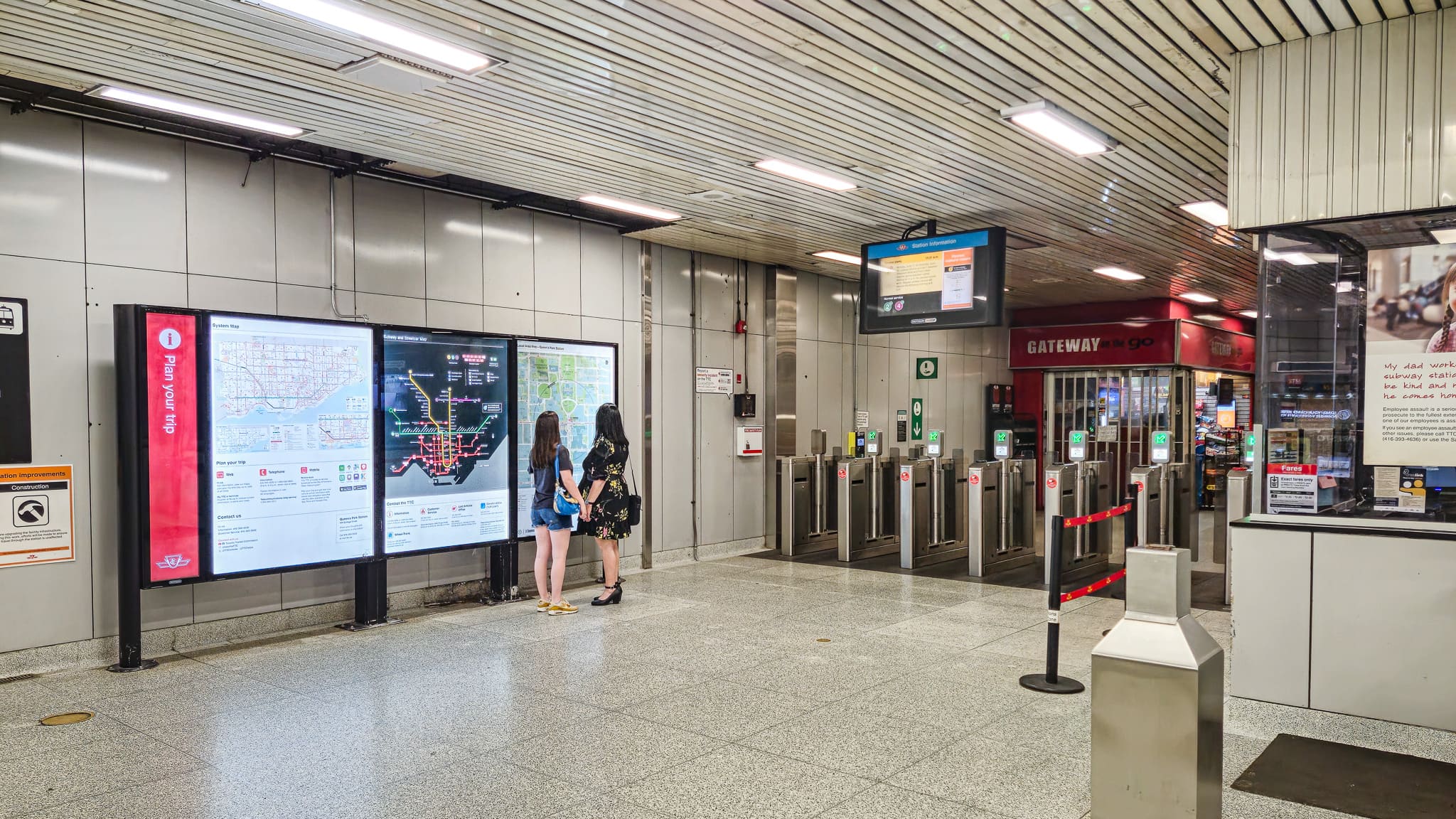 Two people standing in front of a map in a TTC subway station