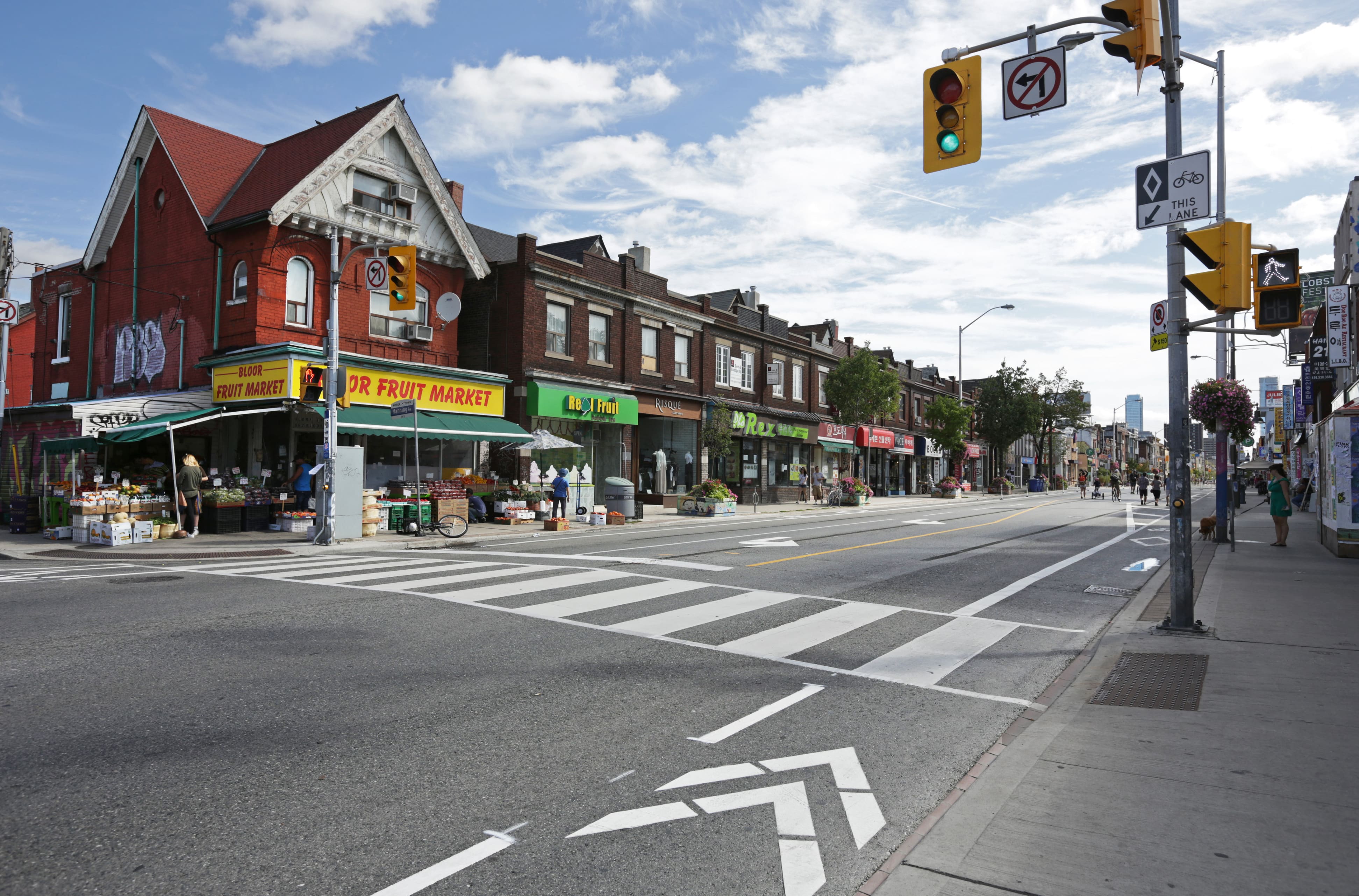 Toronto's Koreatown neighbourhood with colourful storefronts and people walking down the street.