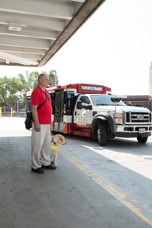 Photo of Tom Richardson standing by a Wheel-Trans vehicle