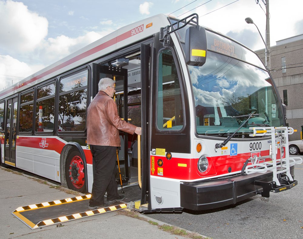 customer with a cane boarding a bus using the ramp 