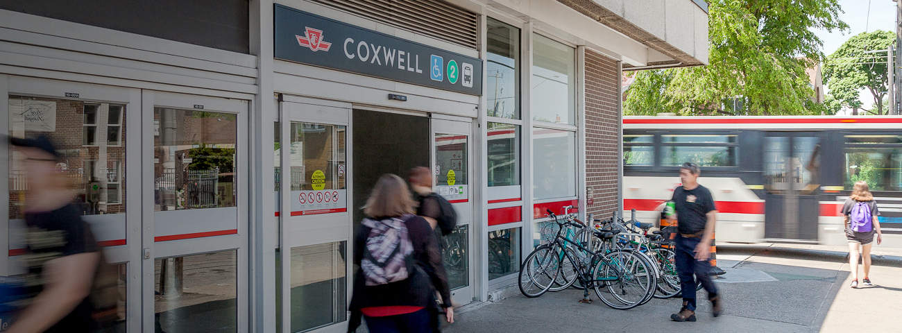 Commuters near Coxwell Station Entrance on Sunny day