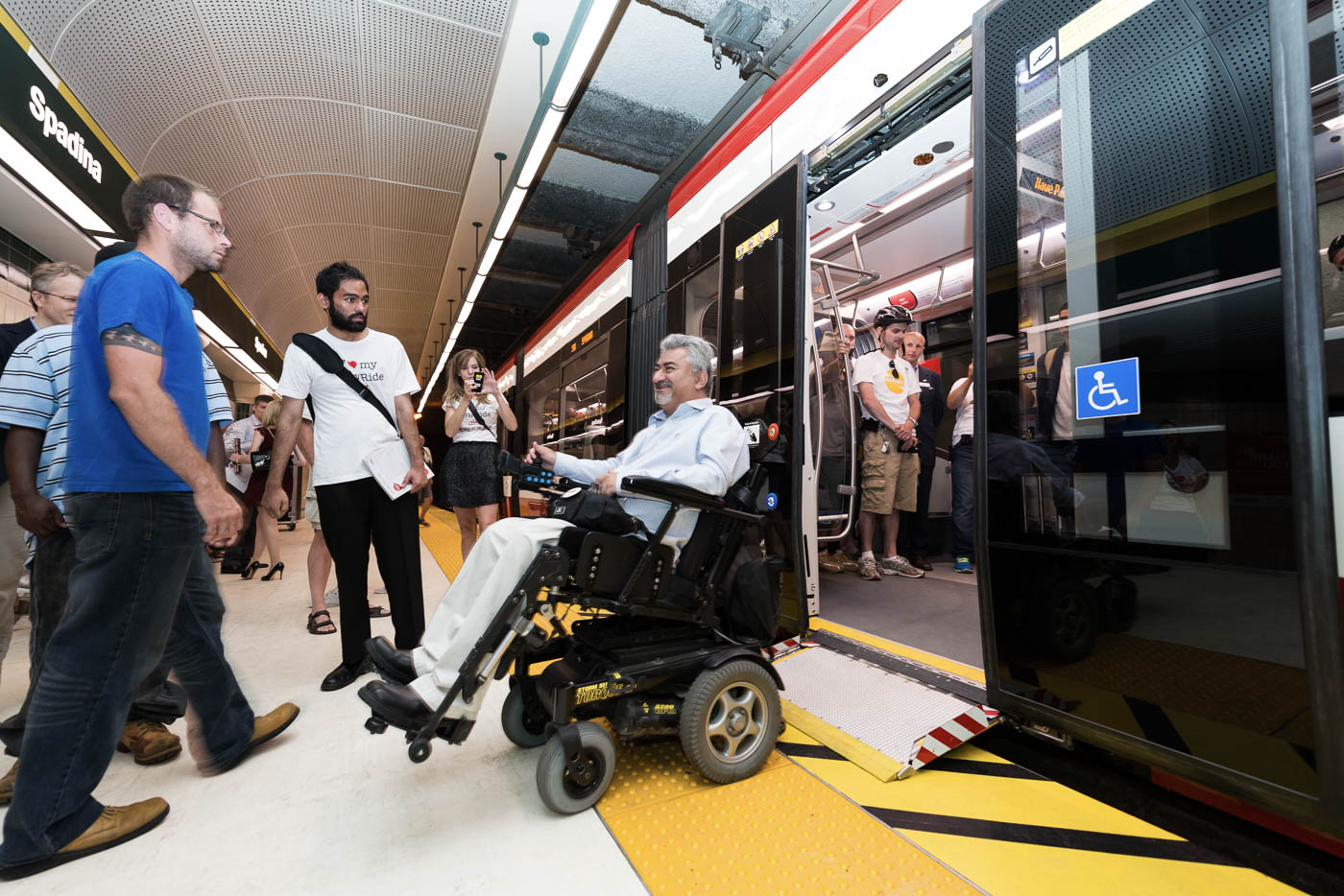 An individual on his wheelchair leaving a leaving a streetcar at Spadina Station