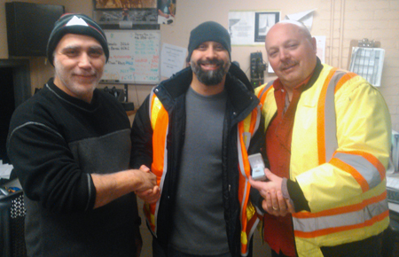 Recipient: Vehicle Repairperson Angelo Tamburello, centre, accepts his 15 year pin. Location: Roncesvalles Carhouse. Congratulated by: Forepersons Joe Perruccio, left, and Barry Tatham, right.