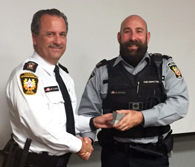 Recipient: Transit Fare Inspector Steve Barreca, right, receives his 10 year pin. Location: Transit Enforcement Unit. Congratulated by: Chief Special Constable Mark Cousins, left.