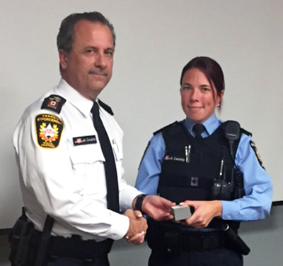 Recipient: Fare Inspectors Team Lead Stephanie Cassidy, right, accepts her 10 year pin. Location: Transit Enforcement Unit. Congratulated by: Chief Special Constable Mark Cousins, left.