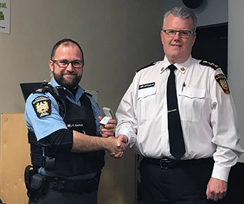 Recipient: Special Constable Sean Salmon, left, accepted his 10 year milestone pin. Location: Transit Enforcement Department. Congratulated by: Head Mike Killingsworth, left.