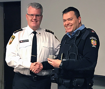 Recipient: Special Constable Trevor Timbrell, left, accepted his 10 year milestone pin. Location: Transit Enforcement Department. Congratulated by: Head Mike Killingsworth, left.